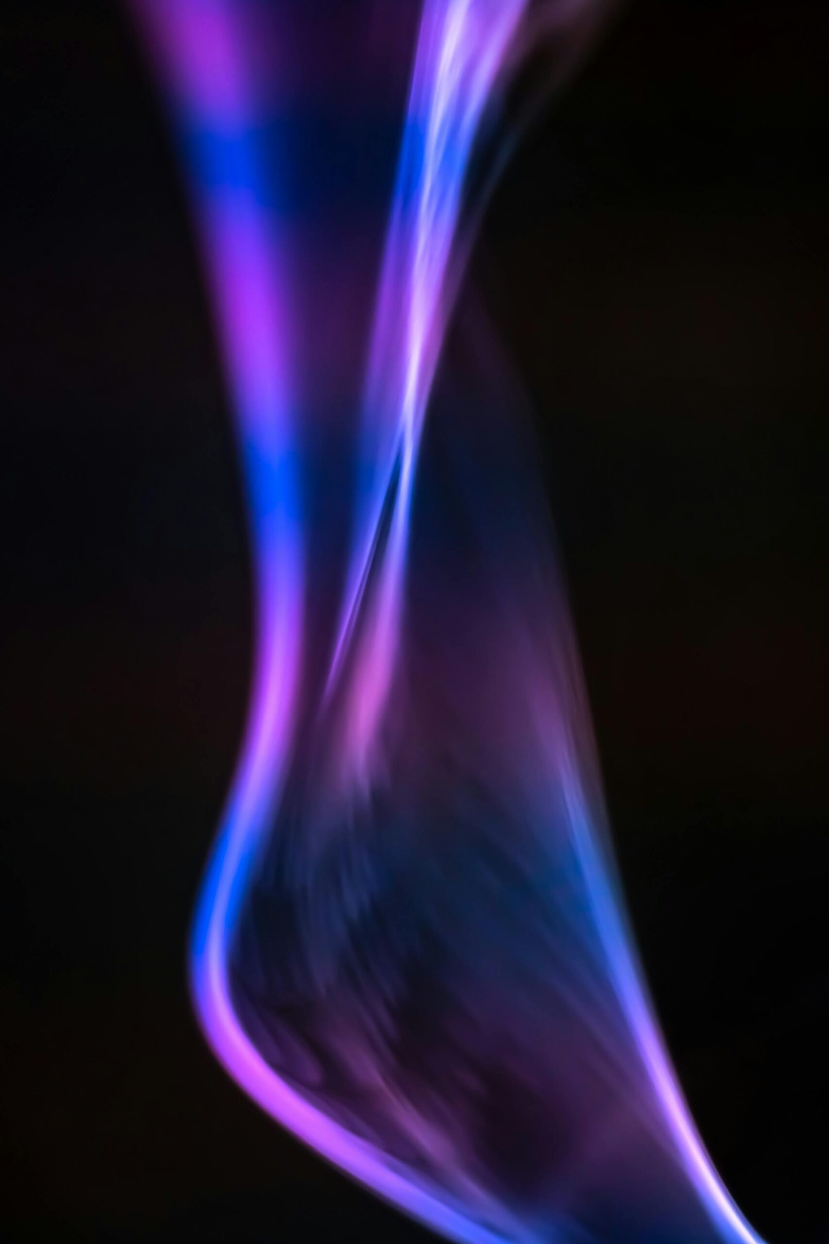 Ethereal abstract image of smoke in vibrant purple and blue hues, creating a mystical atmosphere.